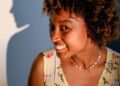 A woman with curly hair smiling in the sun, Positive Phil