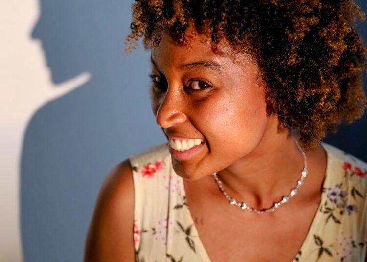 A woman with curly hair smiling in the sun, Positive Phil