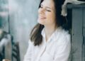A woman in a white shirt smiling with closed eyes, Positive Phil