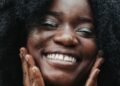 A woman with curly hair smiling warmly, Positive Phil