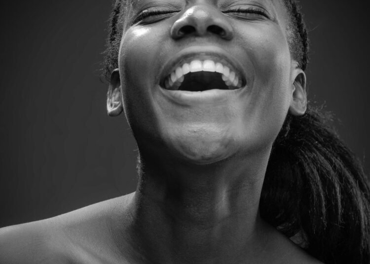 A joyful smiling woman in a studio portrait, Positive Phil