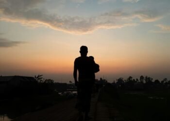 A silhouette of a man running at sunset