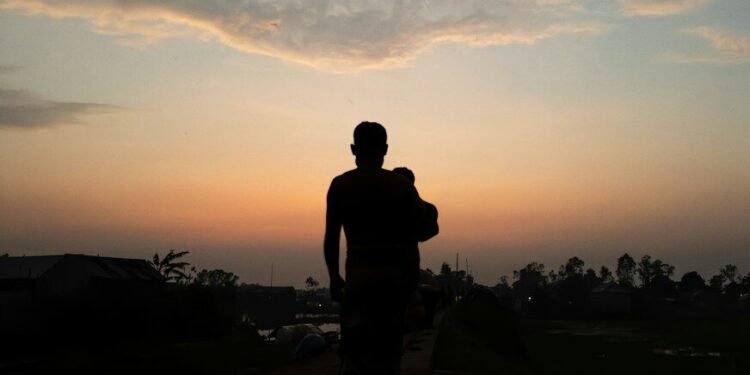 A silhouette of a man running at sunset