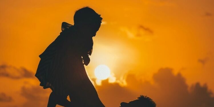 silhouette photo of man carrying baby during golden hour