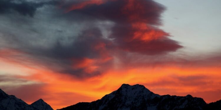 a red and orange sky with a mountain in the background